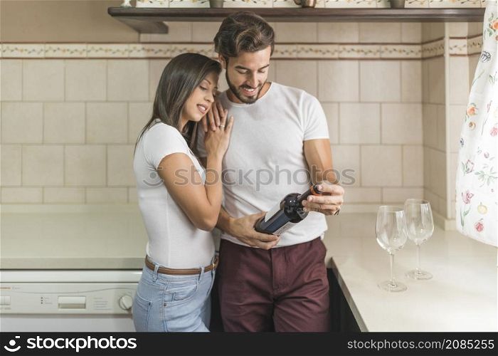 woman embracing boyfriend with bottle wine