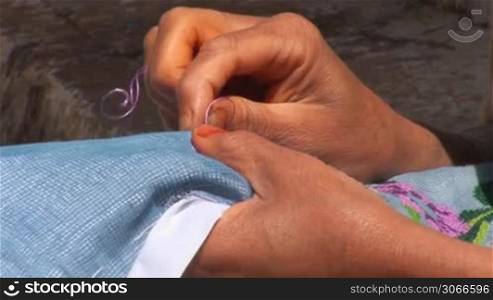Woman embroidering needle pattern