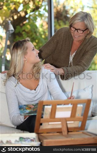 Woman encouraging a young painter at home