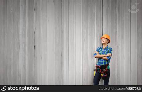 Woman engineer. Attractive smiling woman engineer wearing helmet and tool belt