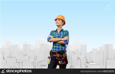Woman engineer. Attractive smiling woman engineer wearing helmet and tool belt