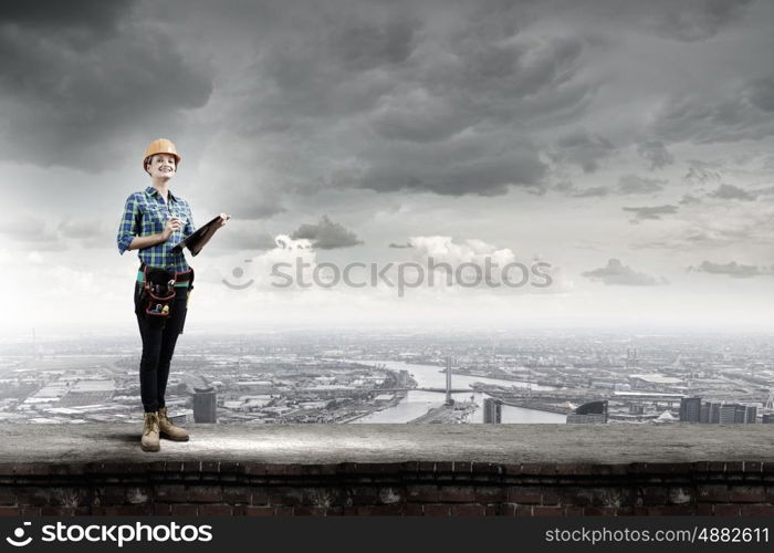 Woman engineer. Attractive woman engineer making some notes and sketches