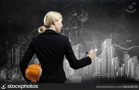 Woman engineer. Close up of businesswoman with yellow hardhat in hand