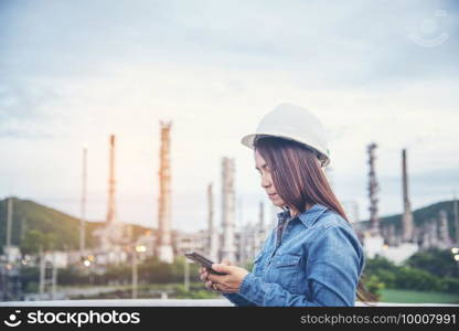 Woman engineer entrepreneur construction industry worker. Female engineer working refinery oil plant manufacturing. Young civil engineering construction wear hard hat safety helmet construction site.