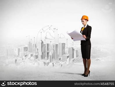 Woman engineer. Image of woman engineer in helmet with drafts. Construction concept