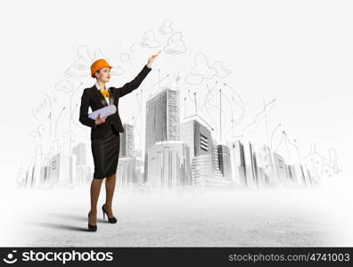 Woman engineer. Image of woman engineer in helmet with drafts. Construction concept