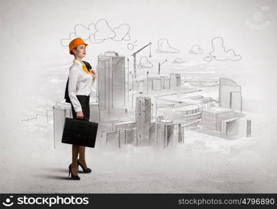 Woman engineer. Image of woman engineer in helmet with drafts. Construction concept