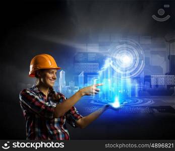 Woman engineer. Image of woman in hardhat pushing icon of media screen