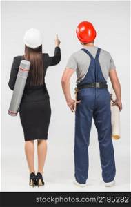 woman engineer standing with builder pointing up