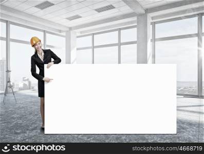 Woman engineer with banner. Attractive woman builder demonstrating white blank banner. Mixed media