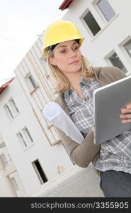 Woman engineer with security helmet standing on construction site