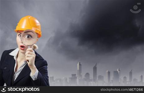 Woman engineer. Young woman engineer looking in magnifying glass