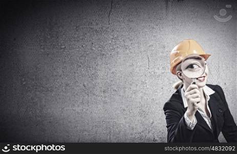 Woman engineer. Young woman engineer looking in magnifying glass