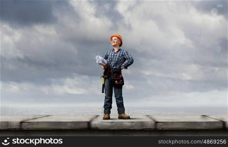 Woman engineer. Young woman in hardhat with construction project in hands