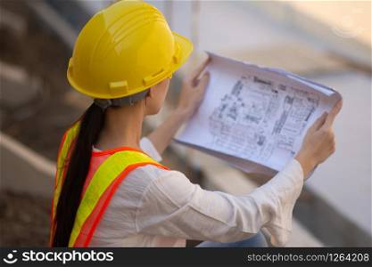 Woman Engineering design hard hat safety suit holding blueprint inspection building estate construction,Working woman