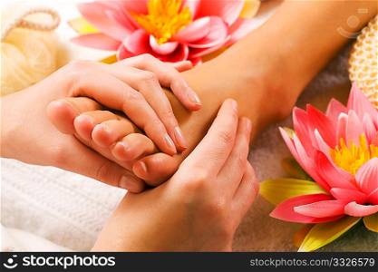 Woman enjoying a feet massage in a spa setting (close up on feet)