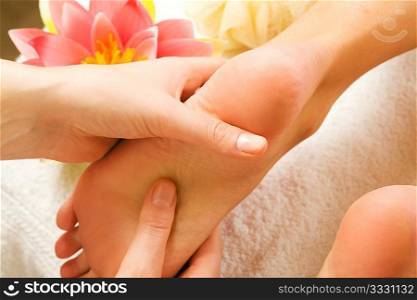 Woman enjoying a feet massage in a spa setting (close up on feet)