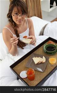 Woman enjoying breakfast in bed