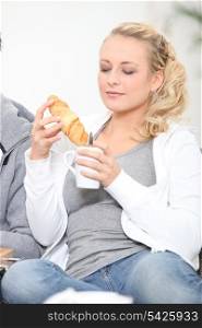 Woman enjoying coffee and croissant