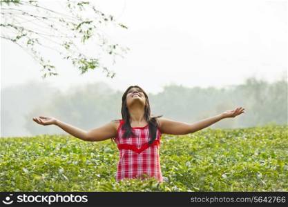 Woman enjoying standing in tea plantation
