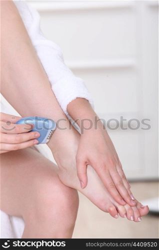 Woman epilating legs