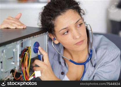 woman examined her computer with a stethoscope