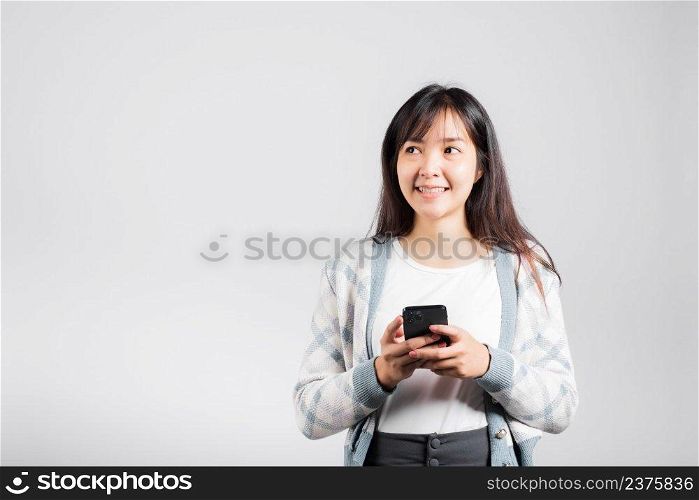 Woman excited read social network feedback on smartphone studio shot isolated white background, young female smiling typing sms message on mobile phone in social media