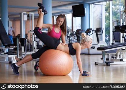 woman exercise and working out with fitness personal trainer in gym
