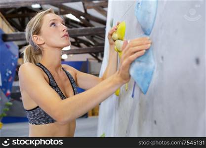 woman exercising at indoor climbing gym