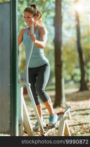 Woman Exercising In Outdoor’s Gym in Public Park, in the Fall