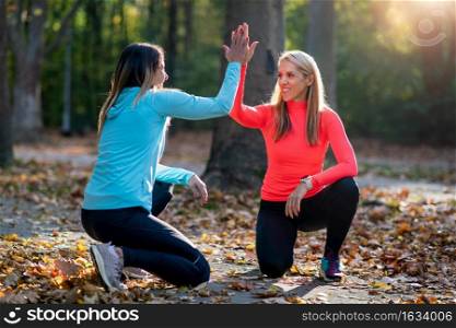 Woman Exercising in Public Park with Personal Trainer.