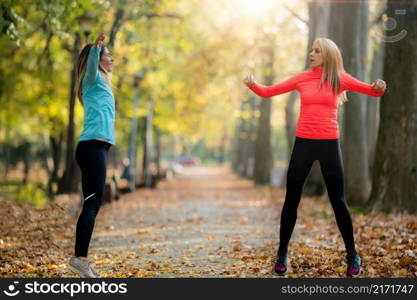 Woman Exercising in Public Park with Personal Trainer in the Fall. Trainer Counting Jumps.. Woman Exercising in Public Park with Personal Trainer.