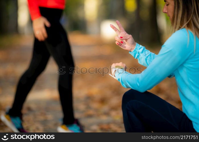 Woman Exercising in Public Park with Personal Trainer in the Fall. Trainer Counting Jumps.. Woman Exercising in Public Park with Personal Trainer.