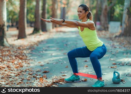 Woman Exercising Legs with Resistance Band Outdoors. Woman Exercising with Resistance Band Outdoors