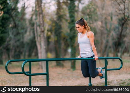 Woman Exercising on Parallel Bars in the Park.. Exercising on Parallel Bar, Outdoor Gym