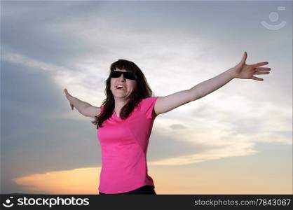 Woman Exercising on the beach at sunset in sunglasses, shades