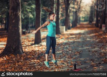 Woman Exercising Outdoors in The Fall, in Public Park