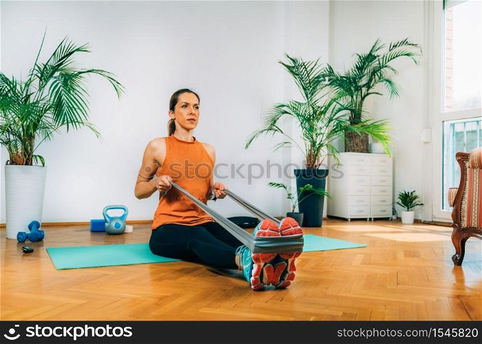 Woman Exercising with Elastic Band. Rowing Exercise Strength Training.