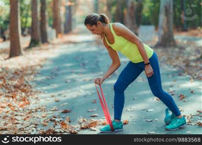 Woman Exercising with Elastic Resistance Band in the Park. Woman Exercising with Resistance Band Outdoors