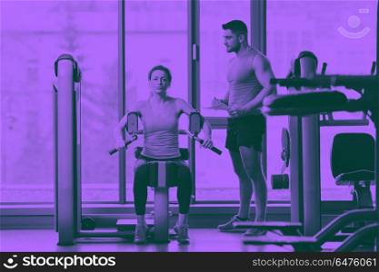 woman exercising with her personal trainer. Gym woman exercising with her personal trainer duo tone