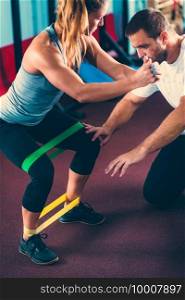Woman exercising with personal trainer in a gym