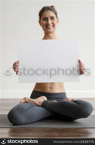 woman exercising yoga holding blank placard