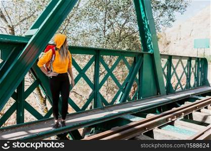 Woman exploring trails and an old iron railroad bridge