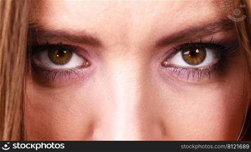 Woman eyes with shadows violet dark color makeup closeup. Serious sad expression. Woman eyes closeup
