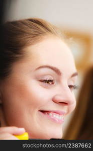 Woman face eyes painting. Girl applying black eye mascara to her eyelashes looking in bathroom mirror. Makeup female beauty. Woman applying black eye mascara to her eyelashes