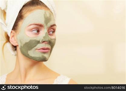 Woman face with green clay mud mask . Skin care. Woman face with green clay mud mask. Girl taking care of oily complexion. Beauty treatment.