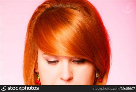 Woman fair hair. Pretty red haired girl on pink background. Studio shot.