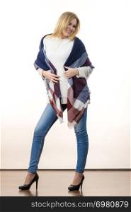 Woman feeling comfortable wearing her soft colorful warm autumnal shawl scarf. Blue jeans, high heels outfit. Autumn outfit accessories concept.. Woman wearing autumn outfit