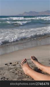 woman feet lying and relaxing on the beach