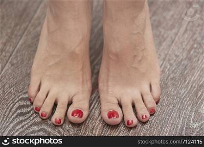 Woman feet on the hardwood surface. Horizontal photo
